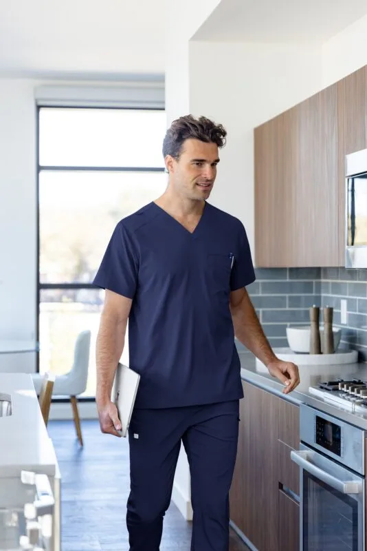 man in blue scrubs standing in scrub store
