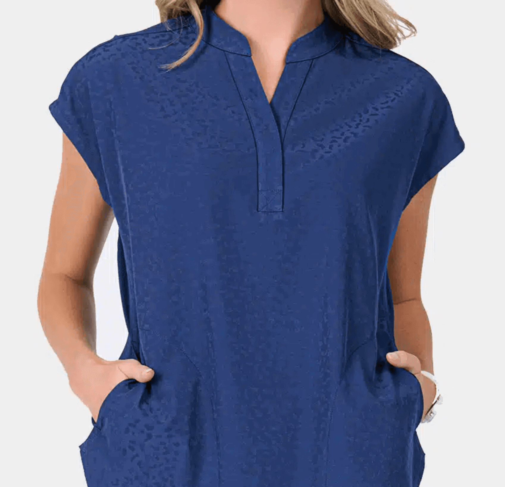 Ava therese scrubs displayed on a mannequin in a bright setting.
