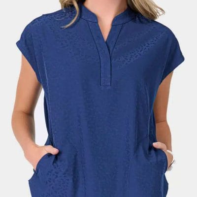 A woman with her hands in her pockets wearing ava therese scrubs from scrubs of evans